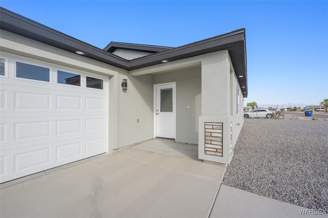 exterior space with a garage and stucco siding