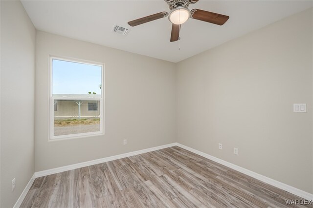 empty room featuring light wood-type flooring, baseboards, visible vents, and ceiling fan