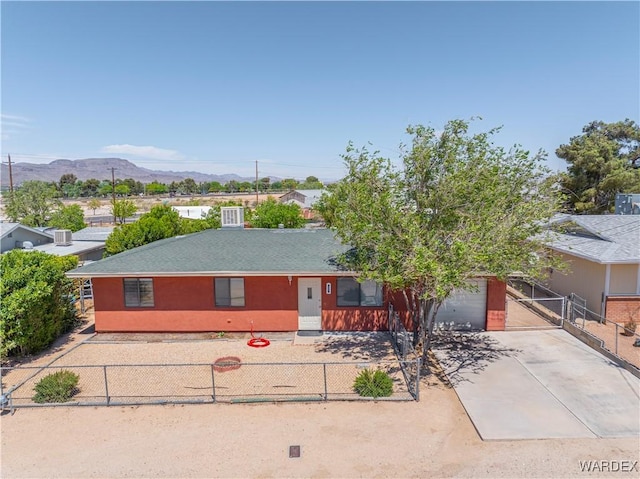 single story home featuring fence private yard, an attached garage, a mountain view, and driveway