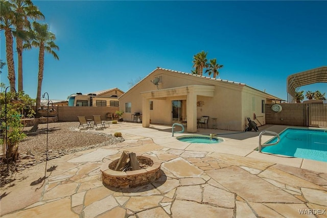 back of house featuring a fenced in pool, stucco siding, a fenced backyard, an in ground hot tub, and a patio