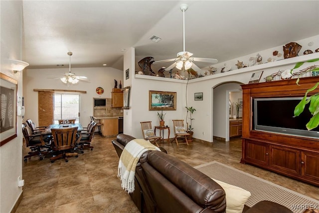 living room with visible vents, a ceiling fan, arched walkways, baseboards, and vaulted ceiling