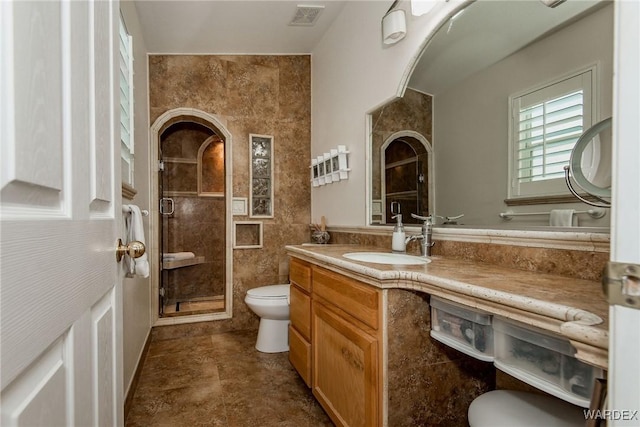 full bathroom with visible vents, a stall shower, toilet, and vanity