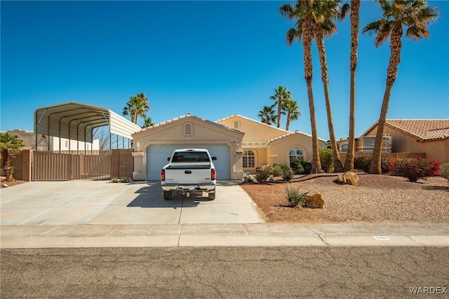 mediterranean / spanish-style home with fence, driveway, a carport, a garage, and a tile roof