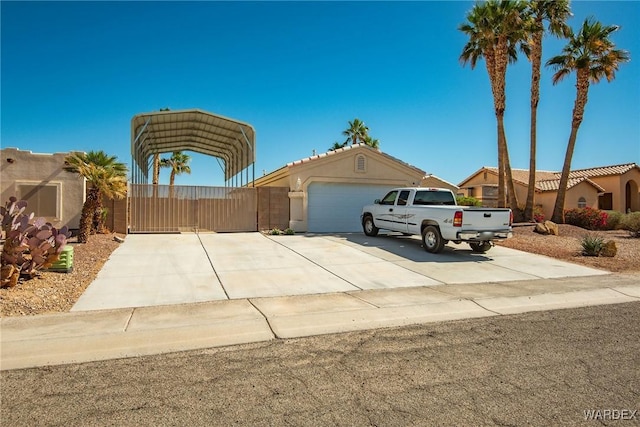 view of front of property featuring a detached carport, concrete driveway, and a gate