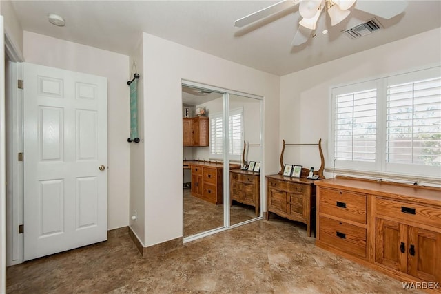 interior space with visible vents and a ceiling fan