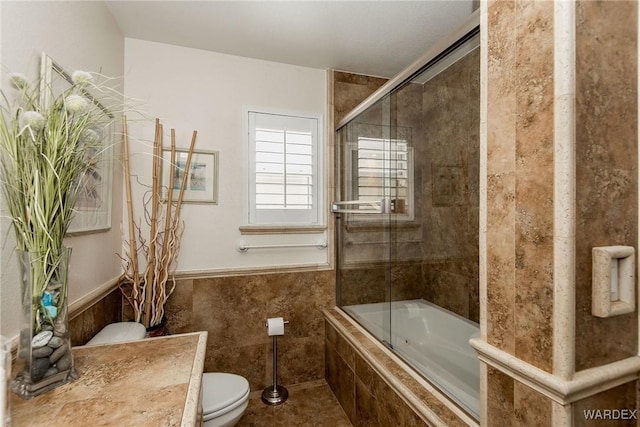 full bathroom with tiled shower / bath combo and toilet