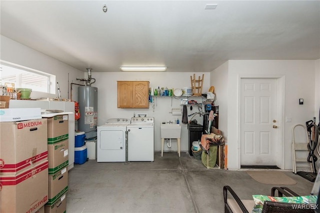 garage with washer and dryer, gas water heater, and a sink