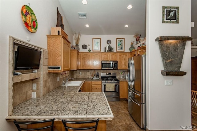 kitchen featuring visible vents, a sink, backsplash, tile countertops, and stainless steel appliances