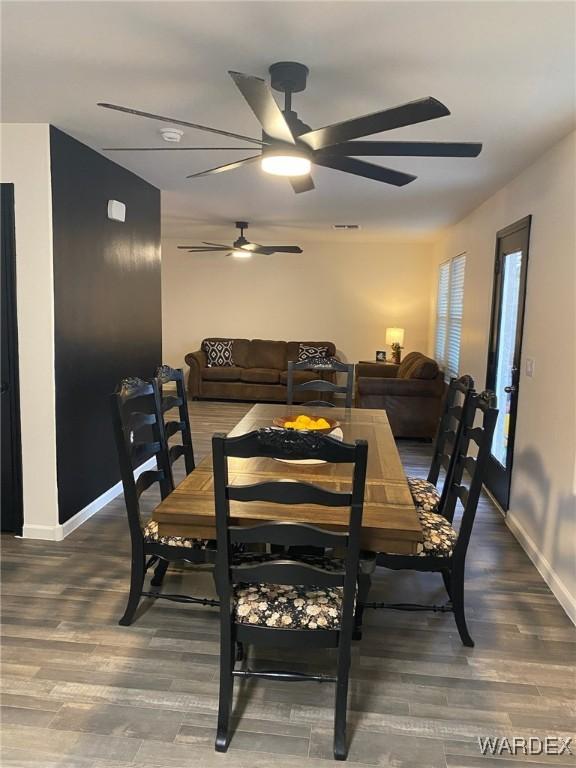 dining space featuring a ceiling fan, baseboards, visible vents, and wood finished floors