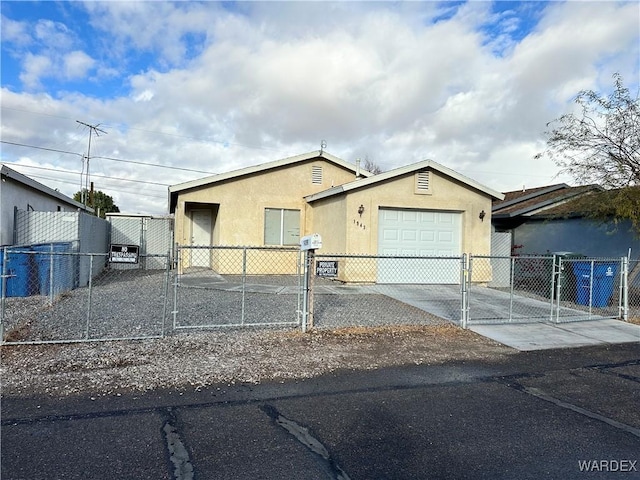 view of front facade featuring driveway, a fenced front yard, a gate, and stucco siding