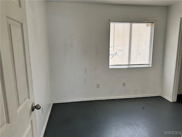 spare room with finished concrete floors and baseboards