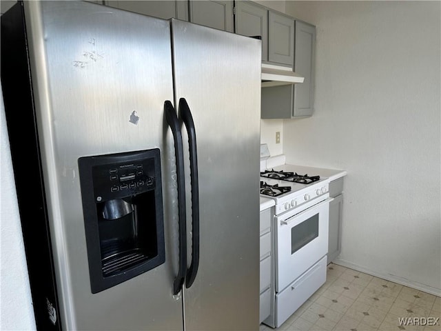 kitchen with stainless steel refrigerator with ice dispenser, white gas range, light countertops, gray cabinetry, and under cabinet range hood