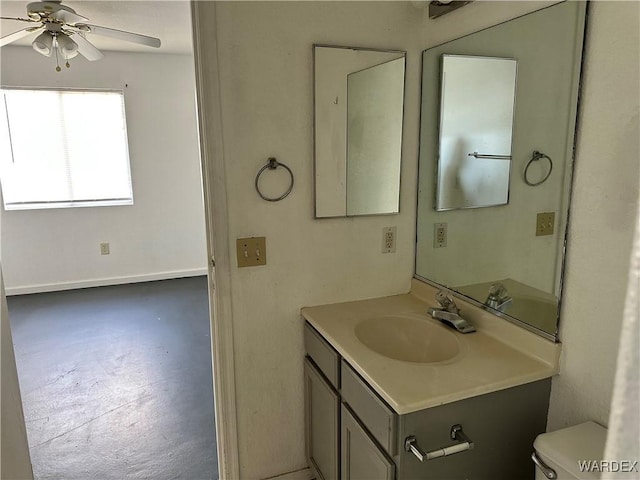 half bathroom featuring toilet, a ceiling fan, and vanity