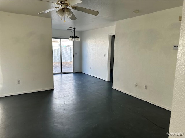 unfurnished room with finished concrete flooring, a textured wall, a ceiling fan, and baseboards