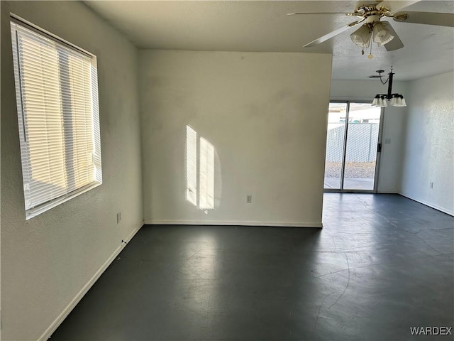 empty room featuring ceiling fan and baseboards