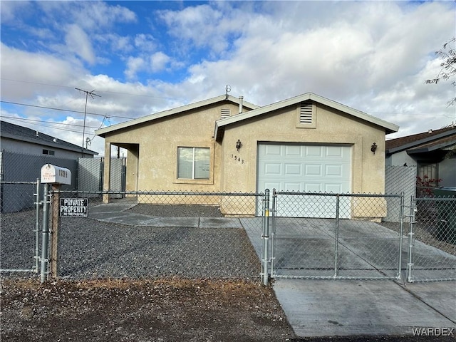 view of front facade with a garage, a gate, concrete driveway, and stucco siding