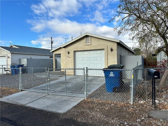 exterior space with concrete driveway, fence, and a gate