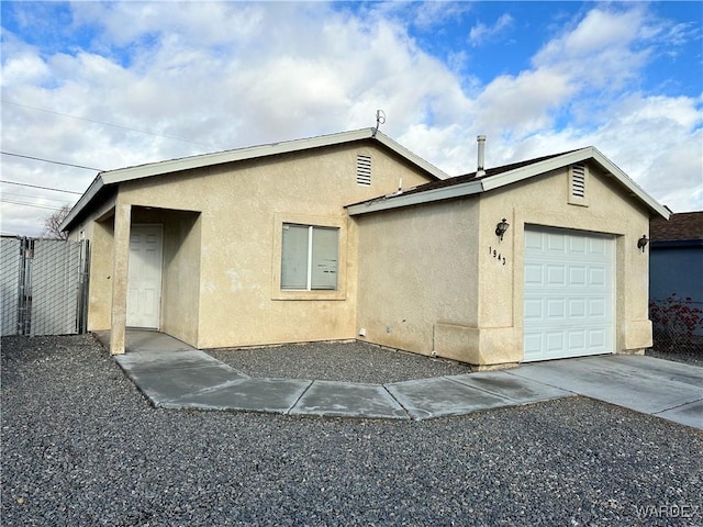 exterior space with a garage, concrete driveway, and stucco siding