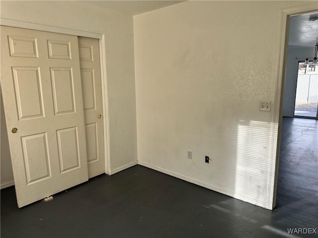 unfurnished bedroom with a closet and concrete floors