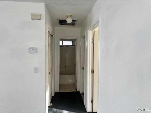 hall with visible vents and tile patterned floors