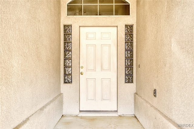 view of exterior entry with stucco siding