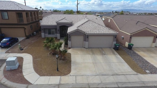 view of front of house with a tile roof, an attached garage, concrete driveway, and stucco siding