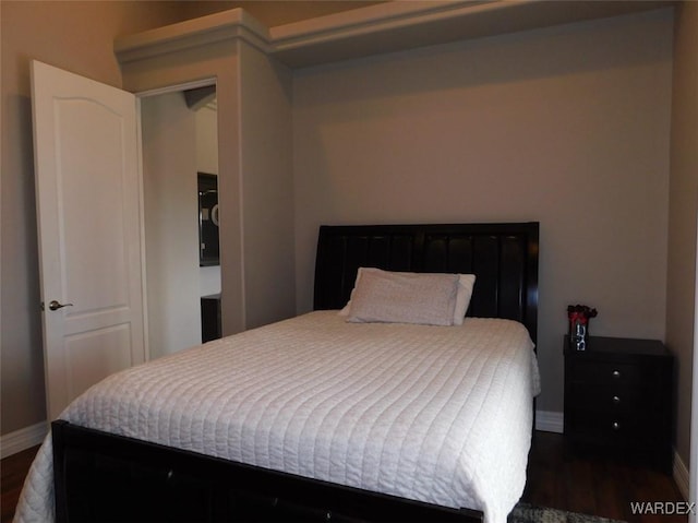 bedroom featuring baseboards and dark wood-style floors