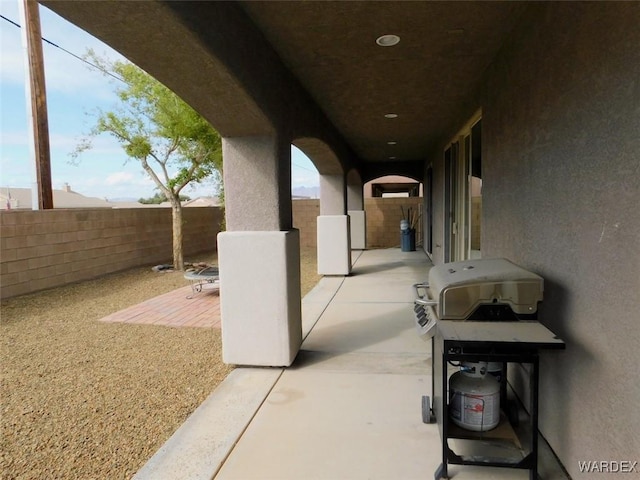 view of patio with a grill and fence