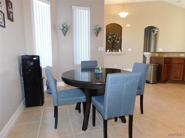 dining room featuring light tile patterned floors, a ceiling fan, and baseboards