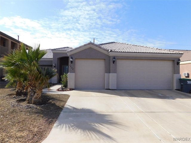 view of front of house with stucco siding, a garage, concrete driveway, and a tile roof