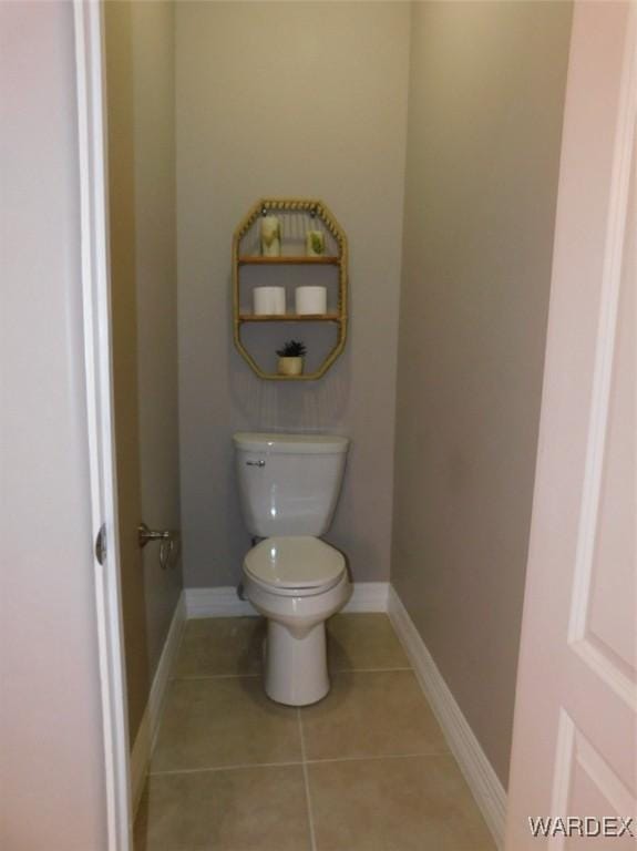 bathroom featuring tile patterned floors, toilet, and baseboards