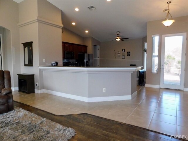 kitchen with light tile patterned floors, visible vents, a peninsula, and black appliances