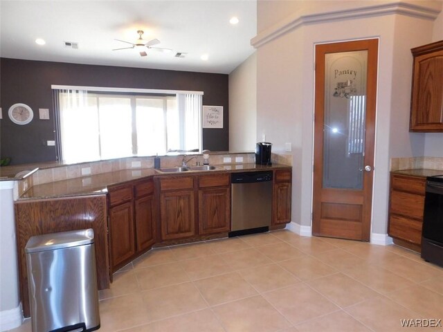 kitchen with stainless steel dishwasher, light tile patterned floors, brown cabinetry, and a sink