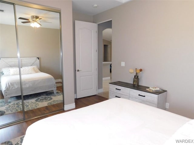 bedroom with a closet, arched walkways, visible vents, and dark wood finished floors