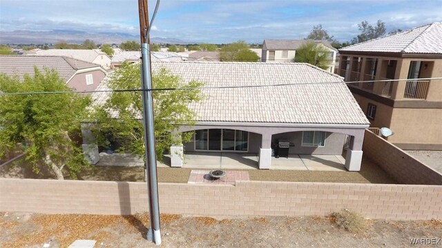 back of property with a patio area, a fenced backyard, stucco siding, and a tiled roof