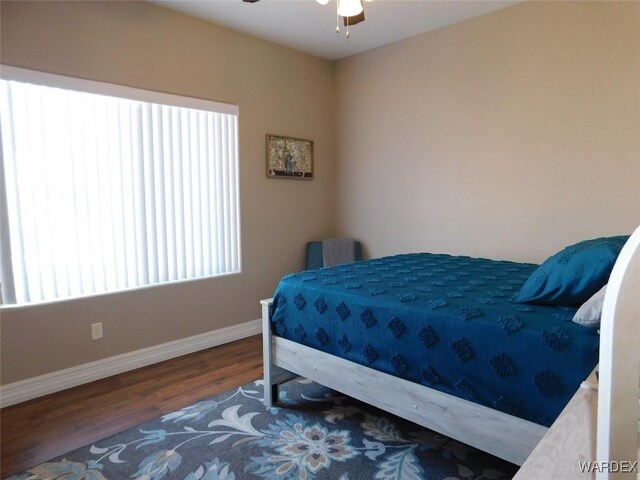 bedroom with baseboards, wood finished floors, and a ceiling fan