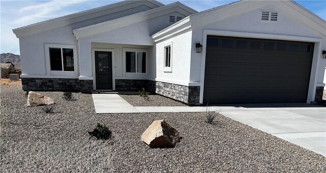 ranch-style home featuring an attached garage and stucco siding