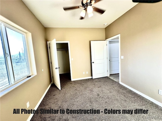 unfurnished bedroom with carpet floors, a spacious closet, baseboards, and a ceiling fan