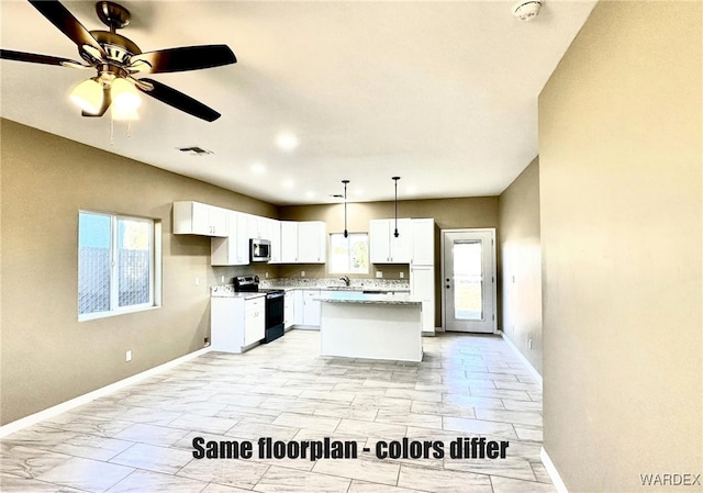 kitchen featuring visible vents, white cabinets, appliances with stainless steel finishes, decorative light fixtures, and a center island