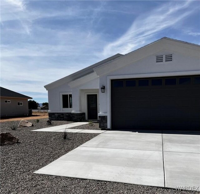 single story home featuring an attached garage, cooling unit, driveway, stone siding, and stucco siding