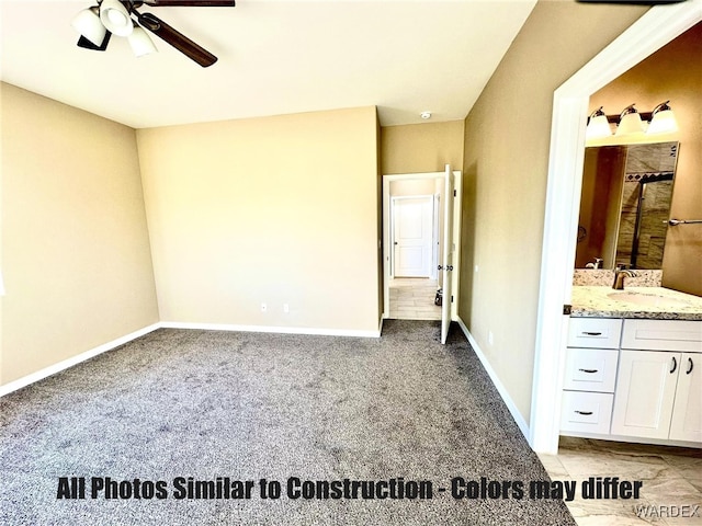 unfurnished bedroom with ensuite bathroom, light carpet, a sink, ceiling fan, and baseboards