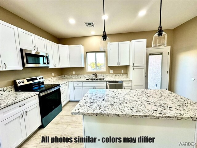 kitchen featuring stainless steel appliances, visible vents, hanging light fixtures, and a sink