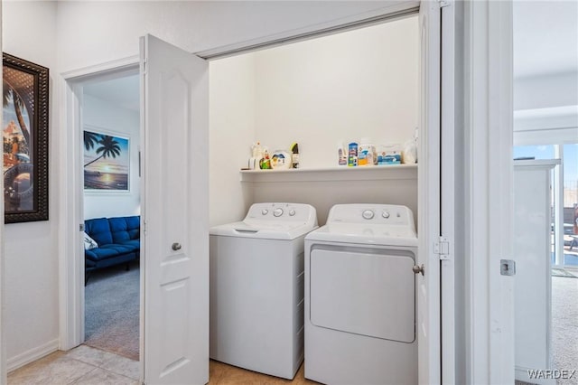 washroom featuring light tile patterned floors, laundry area, and washing machine and clothes dryer