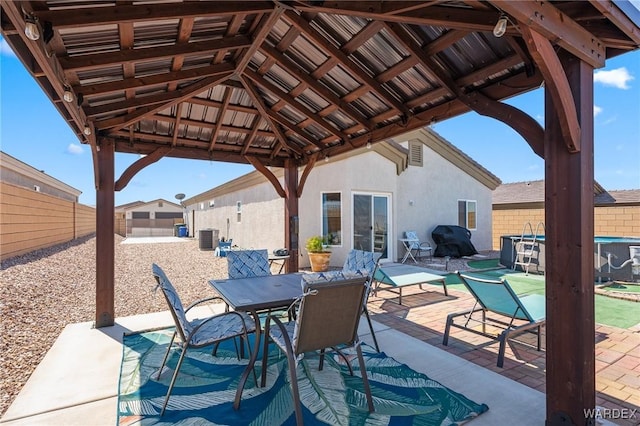 view of patio featuring a fenced backyard, central AC unit, area for grilling, and a gazebo