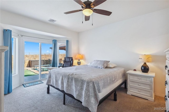 bedroom with access to exterior, light colored carpet, visible vents, and a ceiling fan