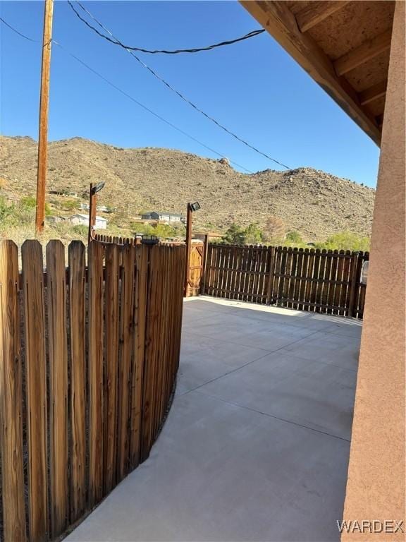 view of patio / terrace featuring fence and a mountain view