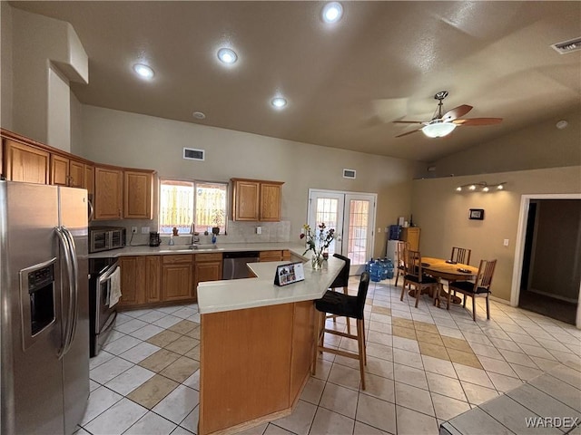 kitchen featuring appliances with stainless steel finishes, light countertops, ceiling fan, a sink, and visible vents