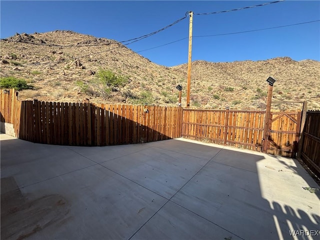 view of patio featuring fence and a mountain view