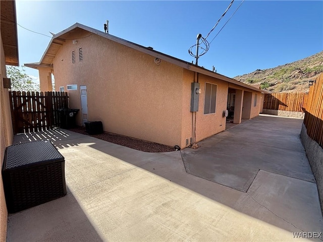 view of property exterior featuring stucco siding, a patio area, and a fenced backyard
