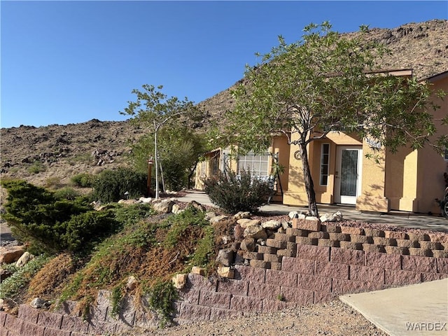 view of home's exterior with a mountain view and stucco siding